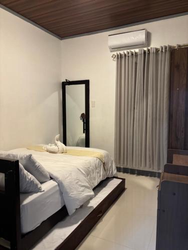 a bedroom with a large bed and a mirror at Spacious Home with Great Location in Panabo City in Panabo