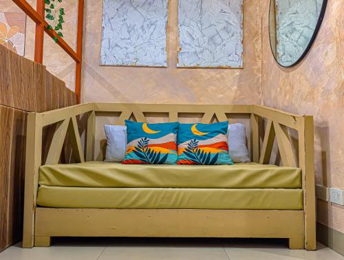 a bench with two pillows on it in a room at Condo in Tagaytay - AB Residences in Tagaytay