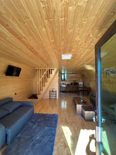 a living room with a couch and a wooden ceiling at Hunter's Cabin in Salkhino