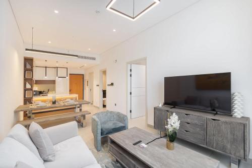 a living room with a couch and a tv at Free housekeeping visits during your stay - StayShort - Modern 2 Bed Sleeps 3 in JVC with City Views in Dubai