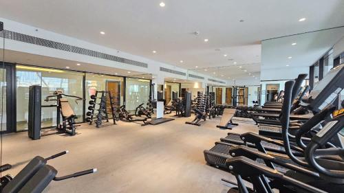 a gym with a lot of treadmills and machines at Free housekeeping visits during your stay - StayShort - Modern 2 Bed Sleeps 3 in JVC with City Views in Dubai