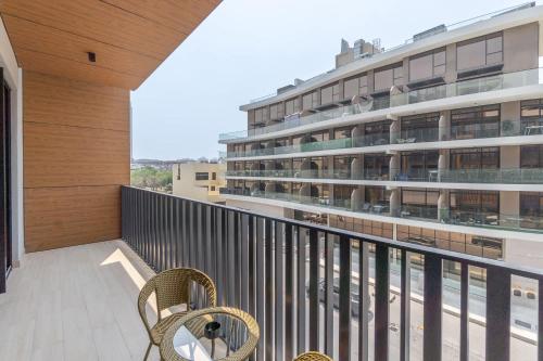 a balcony with two chairs and a large building at Free housekeeping visits during your stay - StayShort - Modern 2 Bed Sleeps 3 in JVC with City Views in Dubai