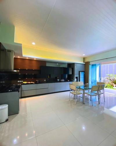 a large kitchen with a table and chairs at The Villa Nirvana Tawangmangu in Tawangmangu
