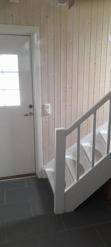 a staircase in a room with a door and a stair case at Palmehagen in Kirkenes