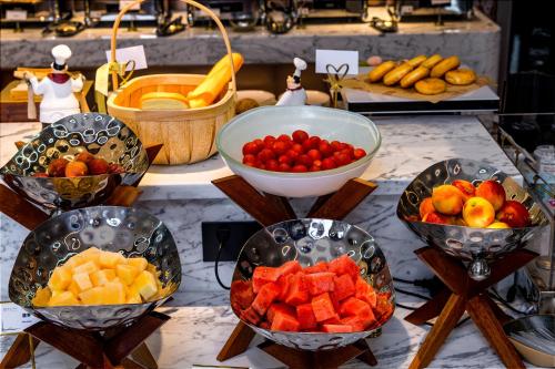 eine Präsentation von Obst in Schalen auf einem Tisch in der Unterkunft Guangzhou Elegant International Hotel Panyu Square Metro Station Branch - Free Shuttle Bus to Canton Fair Complex During Canton Fair Period & Free Deliver Service to Guangzhou Baiyun International Airport in Guangzhou