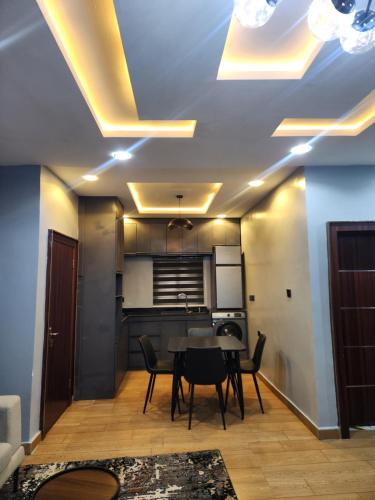 Una cocina y un comedor con mesa y sillas. en Dominica Residence, en Okpanam