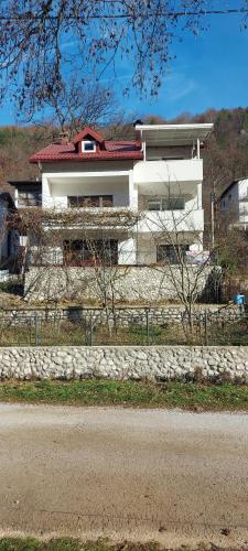 a white house with a fence in front of it at Boračko jezero Apartment "doelend" in Konjic