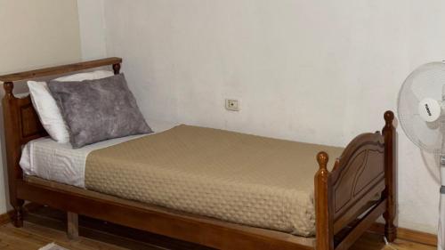 a bedroom with a bed with a pillow and a fan at Gest House Felau in Përmet