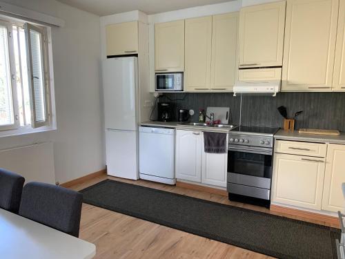 a kitchen with white cabinets and white appliances at 2BR big Apartment A8, free parking on the street in Oulu
