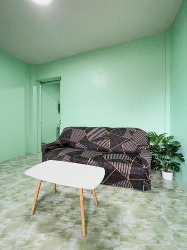a living room with a couch and a white table at Mario Guest House in Ban Tao Than