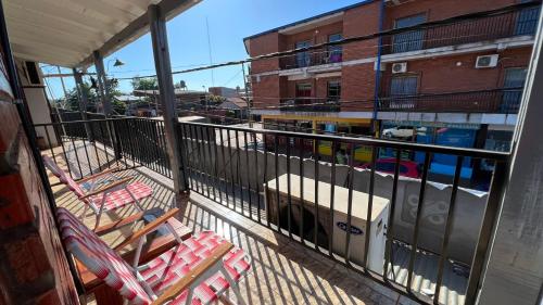 a balcony with lounge chairs and a building at Adhara Apart in Puerto Iguazú