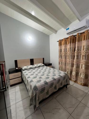 a bedroom with a bed and curtains in a room at Adhara Apart in Puerto Iguazú