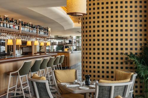 a restaurant with a bar with chairs and tables at Mercury Suite Designer Apartment with Pool Access in St Julian's