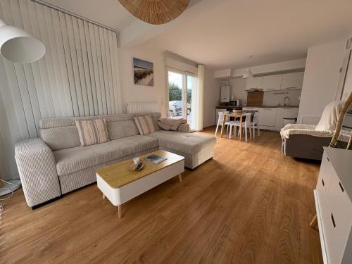 a living room with a couch and a table at Garden and sea in Berck in Berck-sur-Mer
