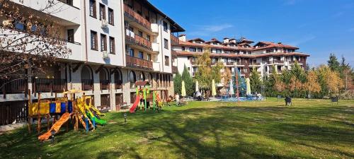 a large building with a grass field in front of a building at Grand Royale Apartment Complex & Spa in Bansko