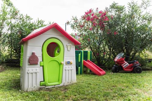 a small toy house with a green door and a playground at B&B LA CORTE SANTA MARIA in Negrar