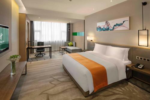 a hotel room with a large bed and a desk at Holiday Inn Chengdu Airport by IHG - Free Shuttle to Shuangliu International Airport in Chengdu