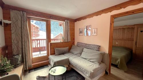 a living room with a couch and a window at Appartement cosy 5-6p aux pieds des pistes 2 chambres 2 sdb in Oz