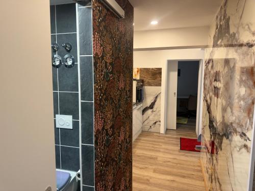 a bathroom with a shower with a tile wall at Apartment Frühling in Bad Langensalza
