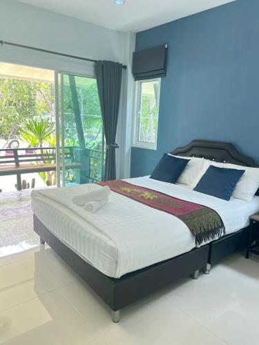 a bedroom with a large bed with blue walls at บ้านพักชายคลอง @บางปู สามร้อยยอด in Ban Bang Pu