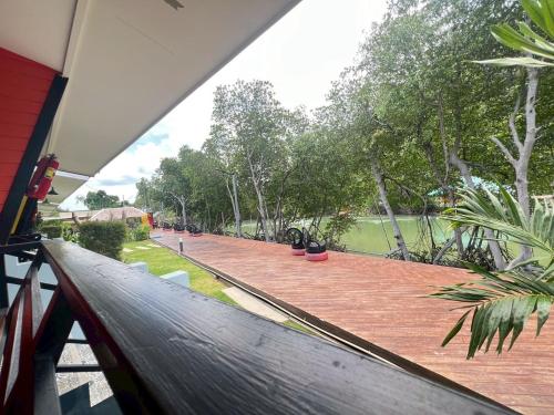a balcony of a house with a view of a garden at บ้านพักชายคลอง @บางปู สามร้อยยอด in Ban Bang Pu