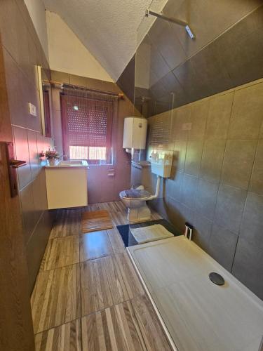 a large bathroom with a tub and a sink at Ruralna kuća za odmor Lika in Lovinac