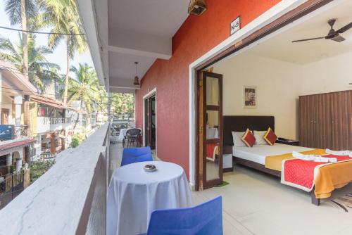une chambre avec un lit, une table et des chaises dans l'établissement Grande Ave Maria Resort, à Candolim