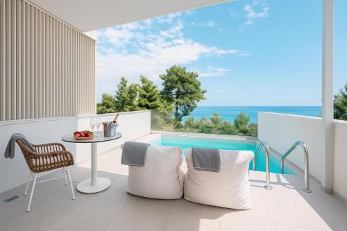 a balcony with a table and a view of the ocean at Gloria Luxury Suites in Kallithea Halkidikis