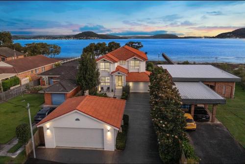 an aerial view of a house with a lake at Bluewatersanctuary holiday house in Tascott