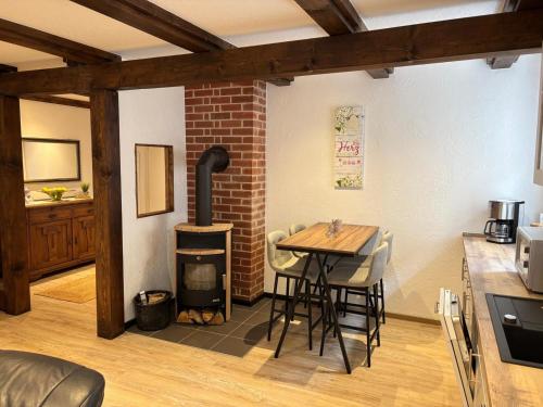 a kitchen with a table and a wood stove at Ferienwohnungen am Grannenhof in Einbeck