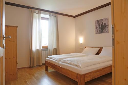 a bedroom with a bed and a window at Der Ulmenhof in Gosau