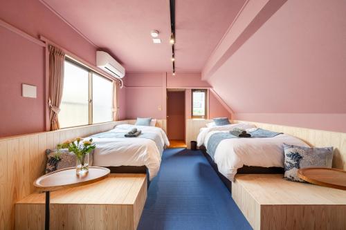 a room with two beds and a table in it at Tokyo Manga Stay 駅1分貸切で85平米 日本の有名マンガが読める宿 9名までOK in Tokyo