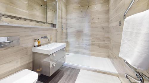 a bathroom with a toilet and a sink and a shower at Panorama Penthouse in Ashford