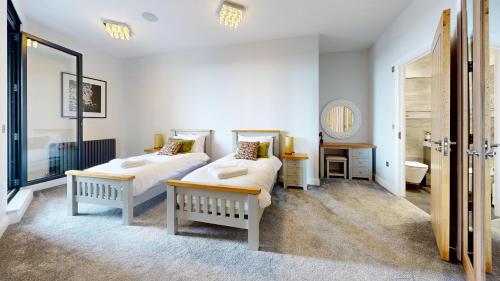 a bedroom with two beds and a mirror at Panorama Penthouse in Ashford