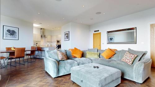 a living room with a couch and a table at Panorama Penthouse in Ashford