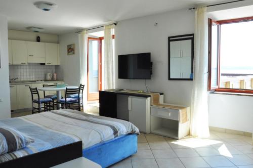 a bedroom with a bed and a kitchen with a table at Apartments & Rooms Riva in Piran