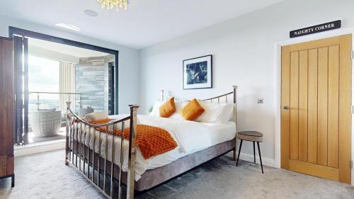 a bedroom with a bed with orange pillows and a window at Panorama Penthouse in Ashford