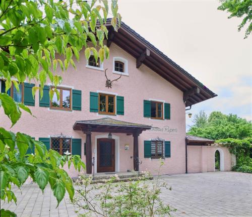 a house with green shuttered windows and a driveway at Landhaus Ruperti in Waging am See