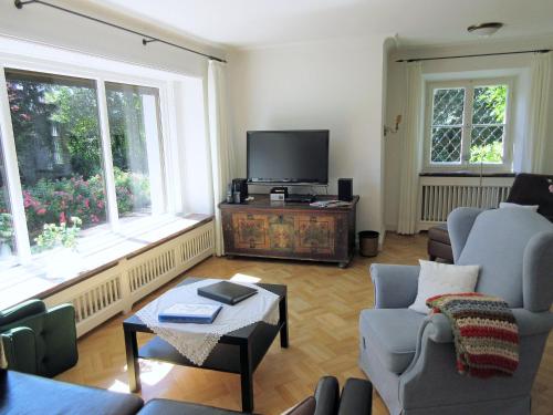 a living room with two chairs and a television at Landhaus Ruperti in Waging am See