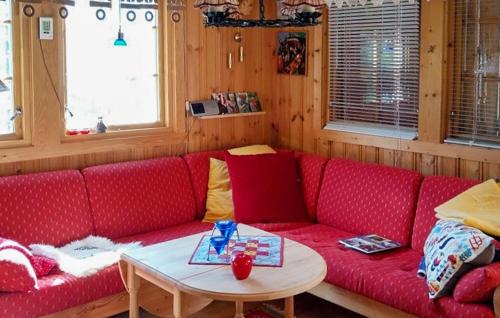 a red couch in a room with a table at 3 Bedroom Beautiful Home In Tynset in Tynset
