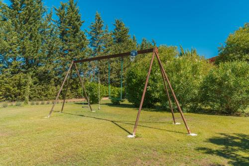 an old swing set in a field of grass at Domaine Plan Des Devens Quiétude in Roussillon