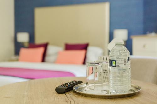 a bottle of water and a remote control on a table at The Osborne Hotel in Torquay