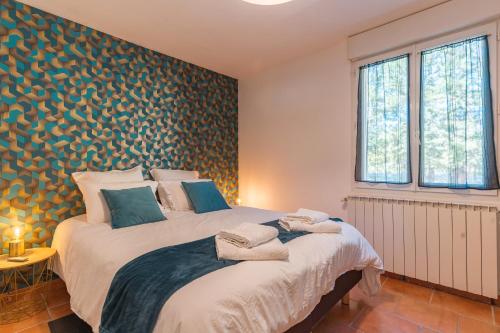 a bedroom with a large white bed in a room at Domaine Plan Des Devens Quiétude in Roussillon