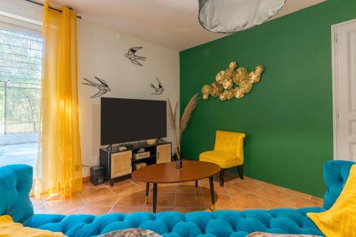 a living room with a blue couch and a table at Domaine Plan Des Devens Quiétude in Roussillon