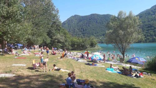 a group of people laying on the grass at a beach at Boračko jezero Apartment "doelend" in Konjic