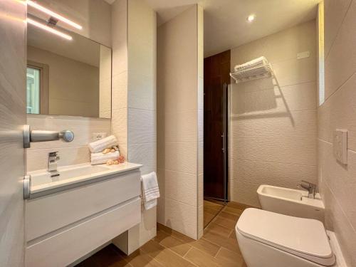a bathroom with a sink and a toilet and a mirror at Ambra Hotel Cattolica in Cattolica