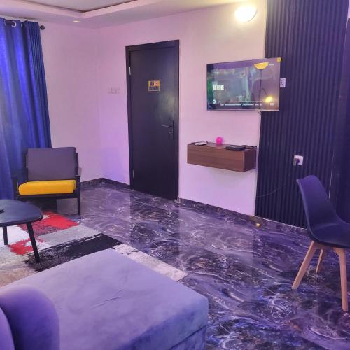 a living room with a marble floor and a tv at WELTONS Apartment BABA YUSUF in Ikeja