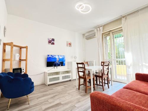 Una sala de estar con una mesa y un televisor. en Niguarda Sweet Home, en Milán
