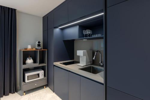 a kitchen with a sink and a microwave at NewCZ Haeundae Residence in Busan