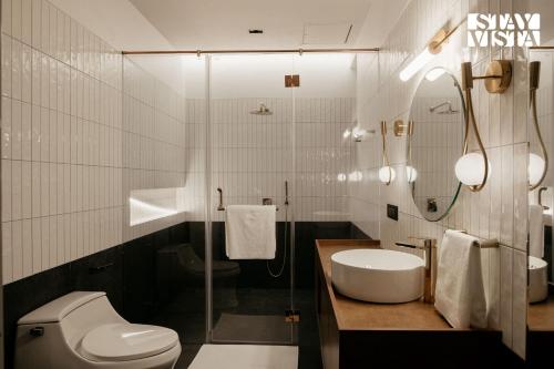 a bathroom with a toilet and a sink and a mirror at StayVista at Casa Canto with Infinity Pool in Siolim